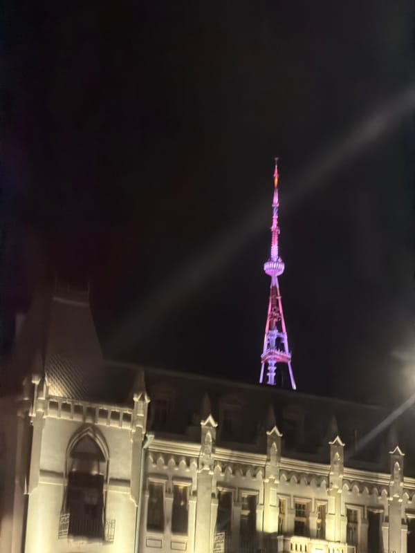 Tbilisi TV Tower displays pink and purple lighting at night