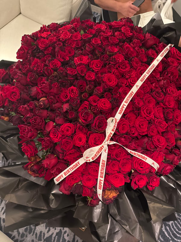 Hotel room birthday celebration captured with roses and ribbons