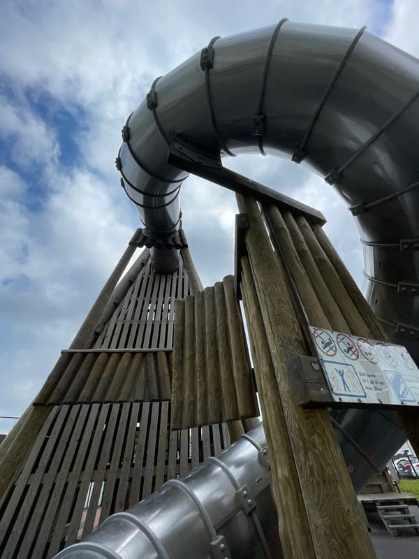 Family playtime documented at Izhevsk playground with tube slide