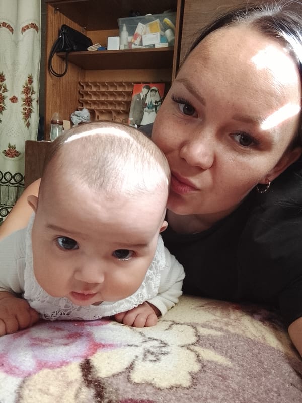 Mother and baby share quiet moment on blanket in Russia
