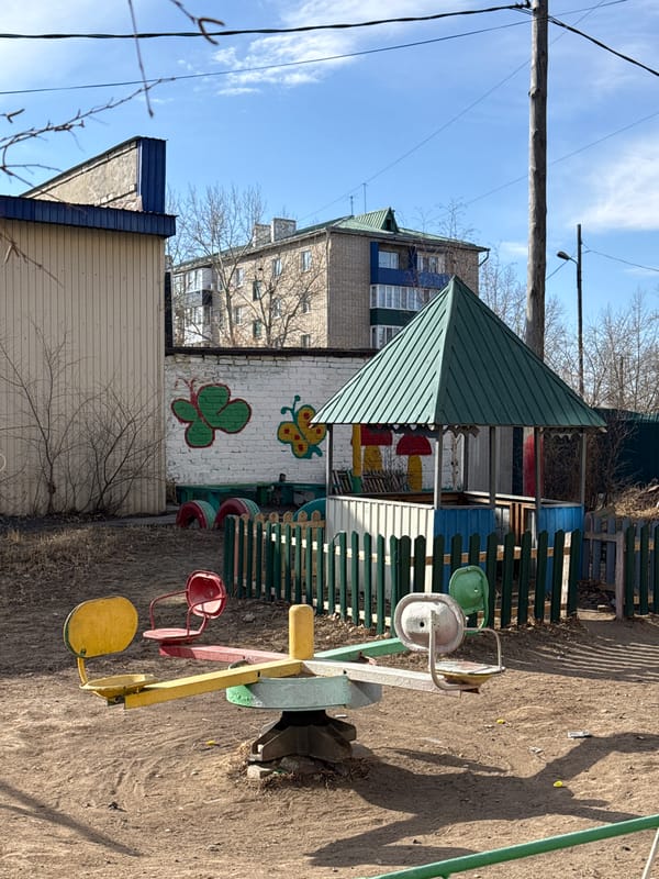 Mural featuring modern green-roofed building documented in Borzya, Russia