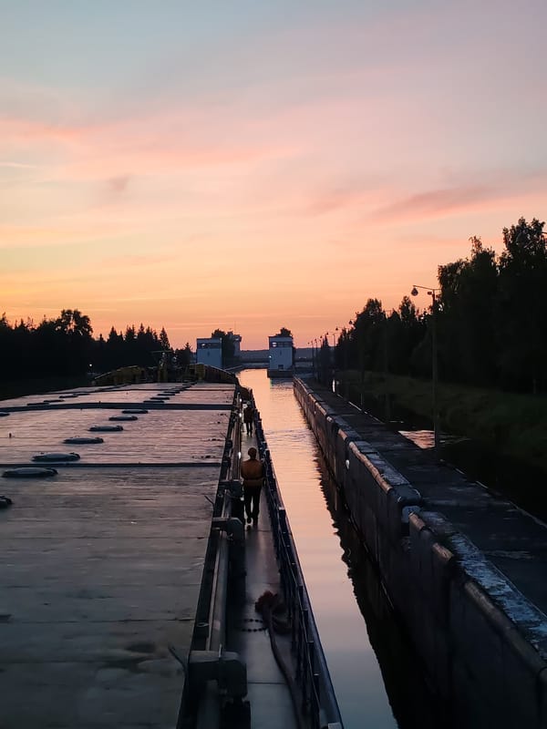 Cargo barge navigates Vytegra canal locks at sunset