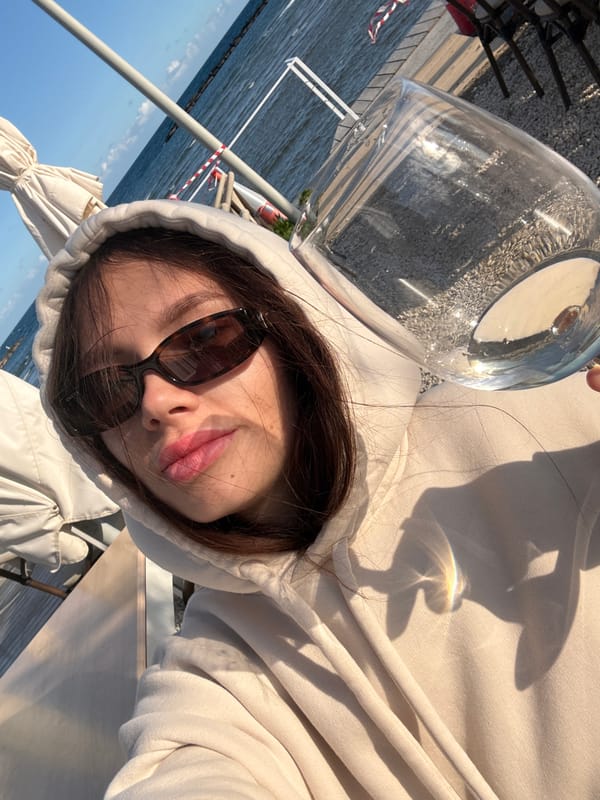 Woman enjoys drink by marina in Oroklini, Cyprus