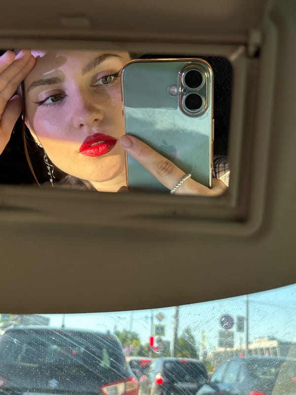 Woman touches up makeup in car mirror on Saint Petersburg street