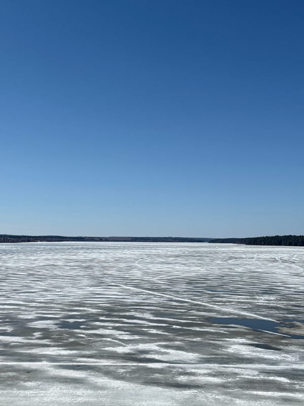 Couple walks frozen waterfront in Votkinsk under clear skies