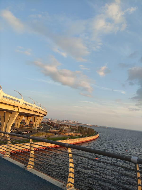 City skyline and waterfront at golden hour, boats passing through