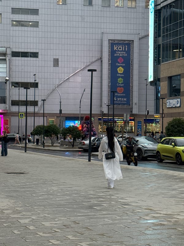 Rainy afternoon pedestrian activity on a Moscow sidewalk