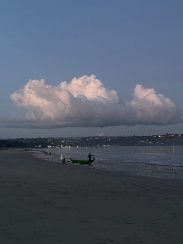 Evening beach scene documented at Kuta with boats, clouds