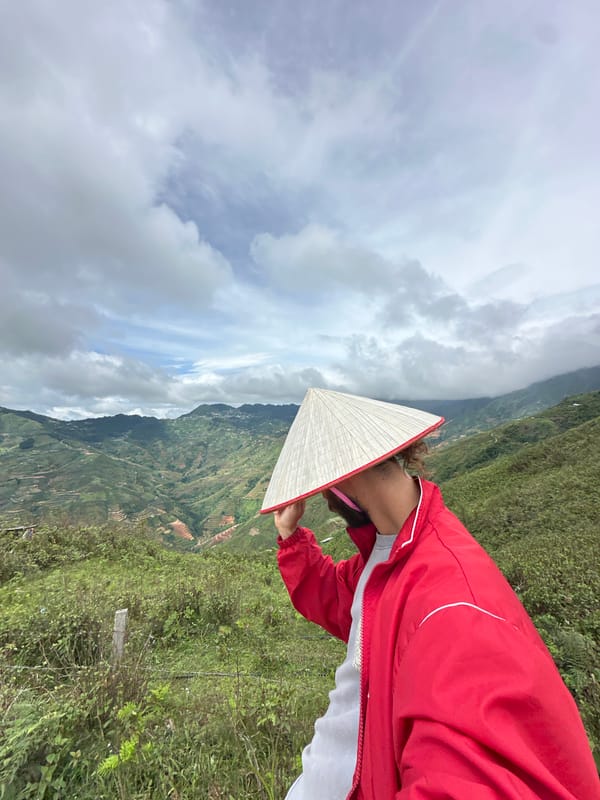 Tourist photographs terraced rice fields in Ta Xua Vietnam