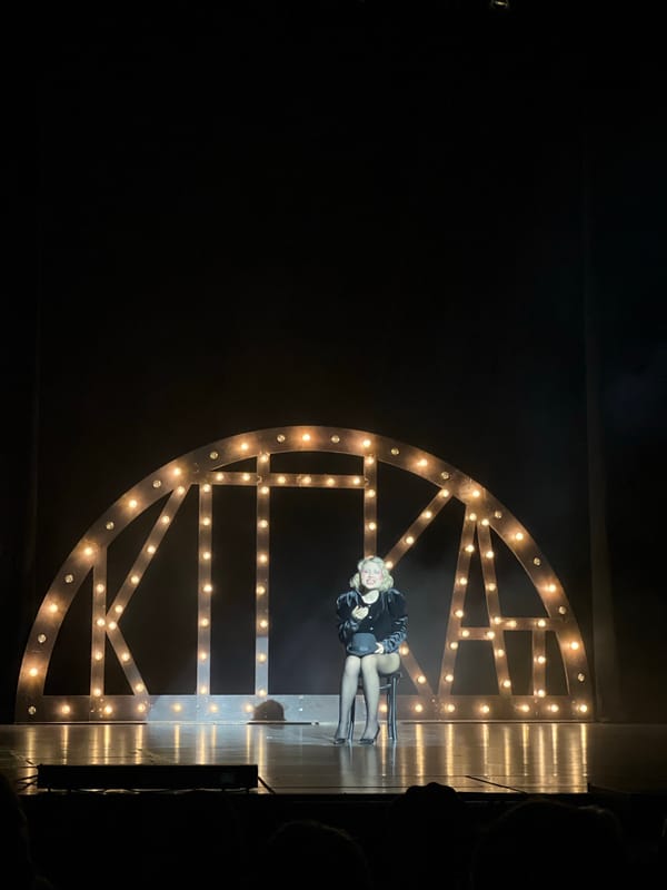 Stage performance captured in Moscow featuring woman on chaise lounge