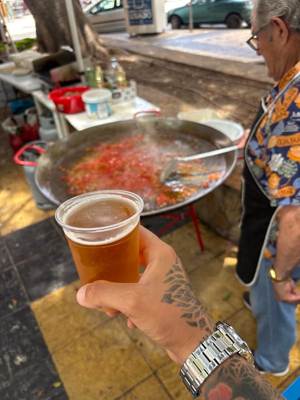 Street paella cooking observed in flower-strewn Málaga