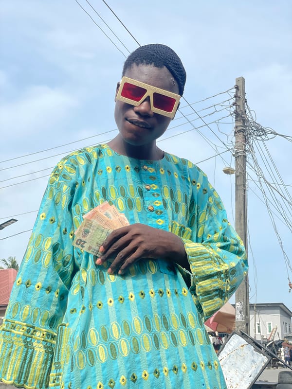 Man displays cash on Ado streets in patterned clothing