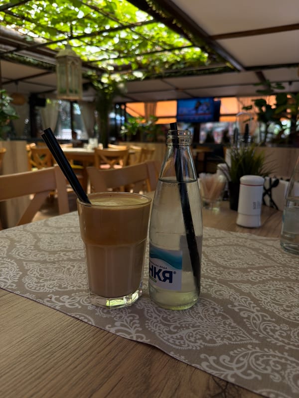 Frappe and mineral water at a shaded outdoor café in Blagoevgrad