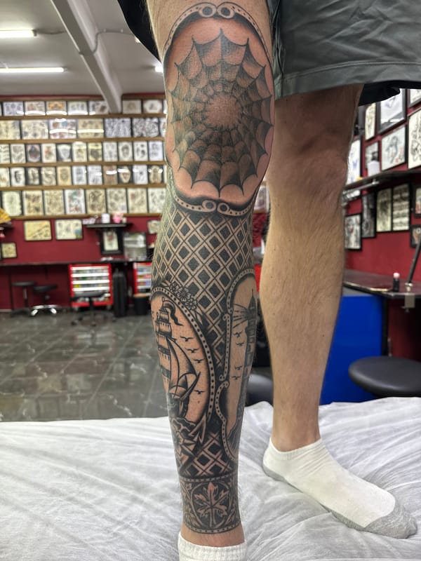 Elaborate leg tattoo with spiderweb and sailboat designs observed in Moscow
