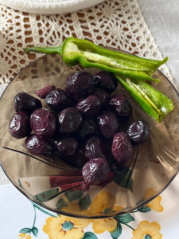 Fresh vegetables and olives arranged across multiple surfaces