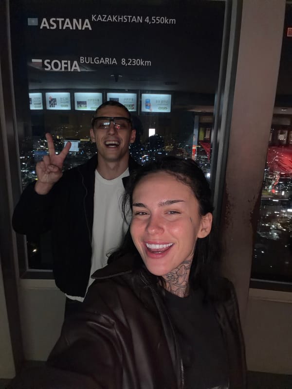Two people photographed indoors with Seoul cityscape backdrop