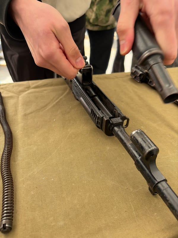 Person handles disassembled AK rifle components in Izhevsk