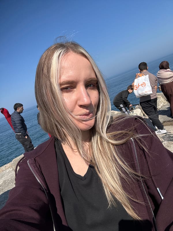Girl stands on seaside concrete structure in Arnavutköy