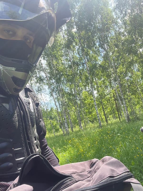 Motorcyclist rides through lupine meadow near Vasilyevo, Russia
