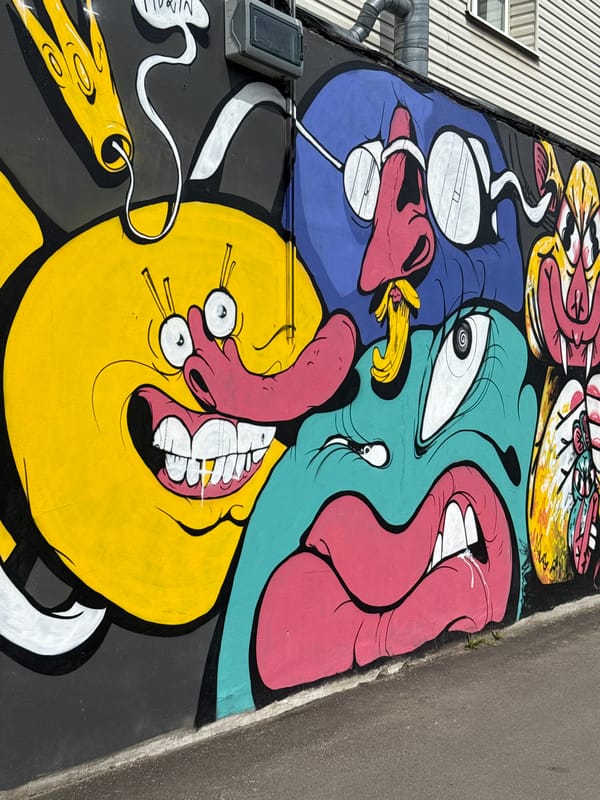 Woman walks past colorful street art in Riga