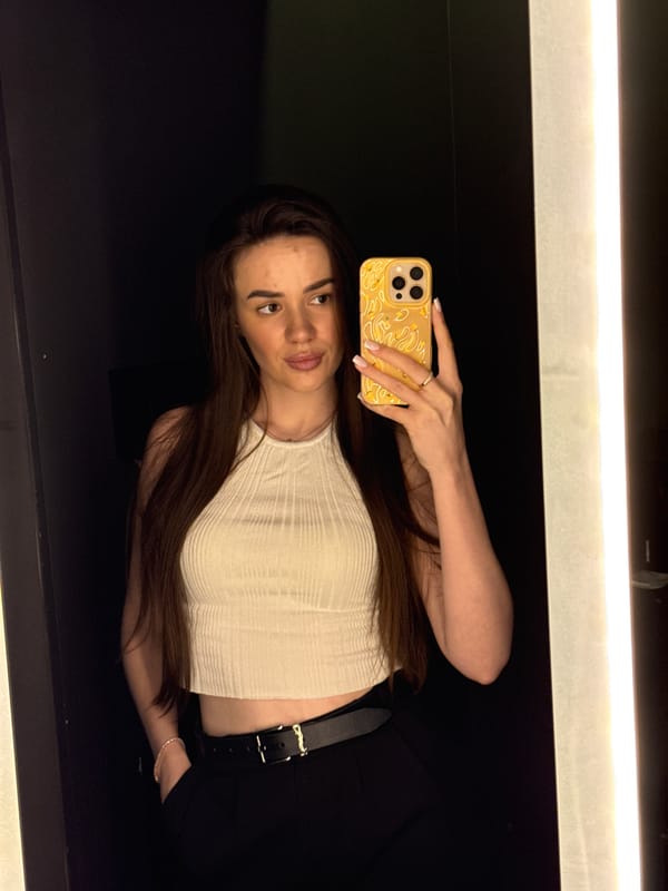 Fitting room selfie session in a white ribbed top