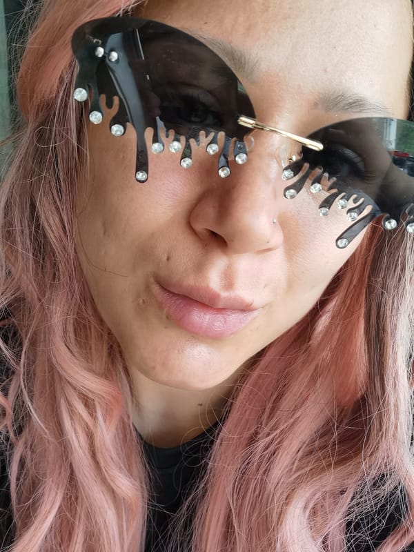 Pink-haired person photographed in decorative sunglasses in Chaikovsky
