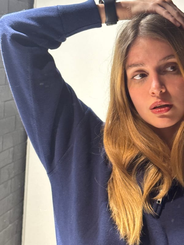 Woman takes mirror selfies in navy sweatshirt, Tbilisi