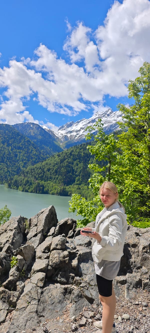 Woman poses at scenic mountain lake overlook in Abkhazia