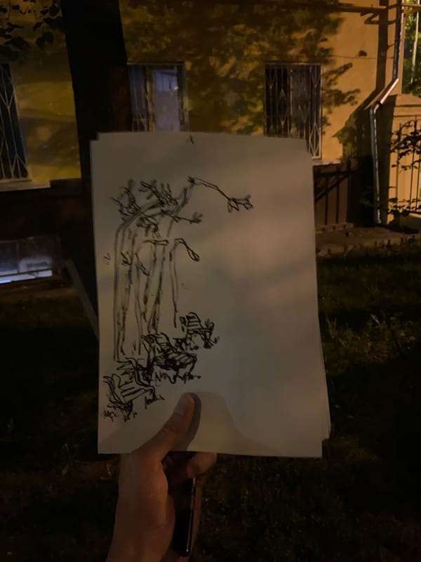 Person displays hand-drawn sketches including portrait outside Moscow building