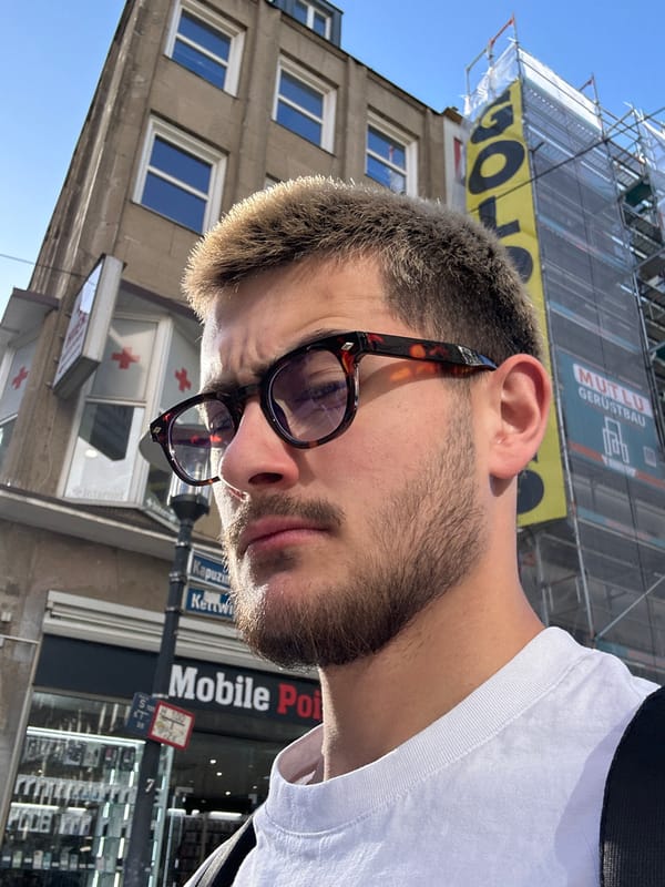 Man takes selfies on Essen street in afternoon sunlight