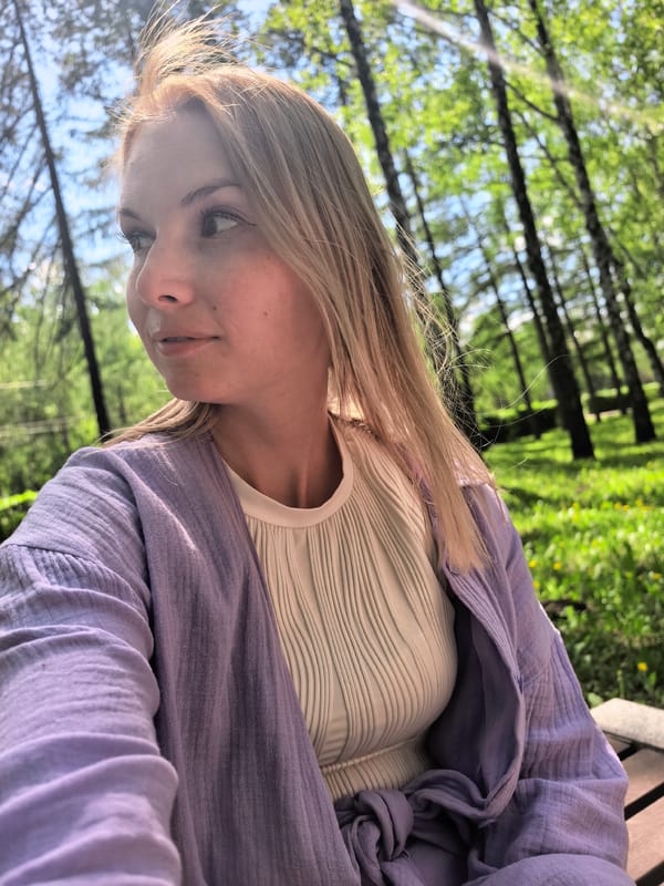 Woman reads book in Sterlitamak park amid birches