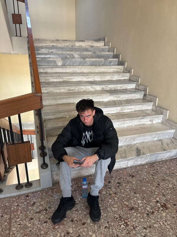 Young man sits on marble stairs in Plovdiv building