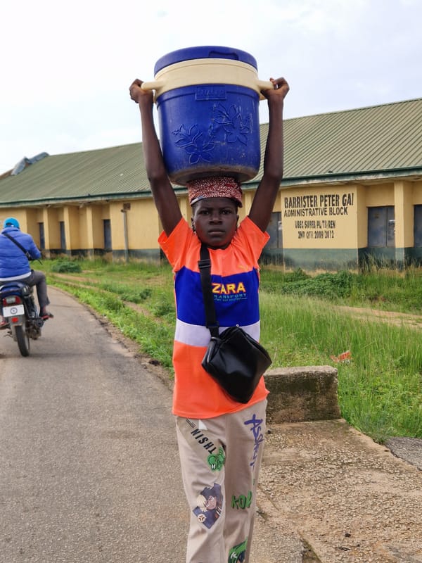 Morning foot traffic in Kabong, Nigeria, people carrying everyday loads