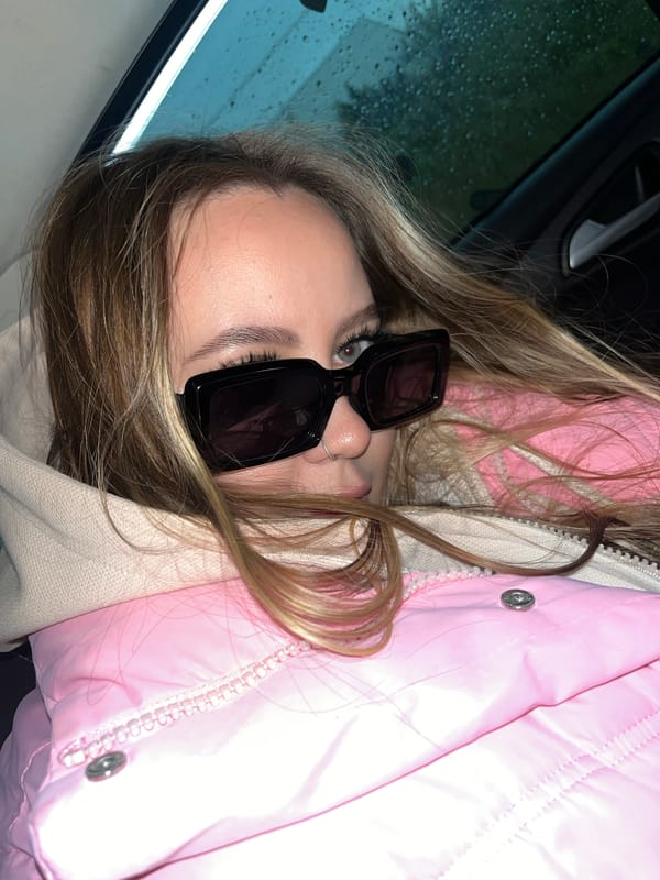 Woman takes selfies in vehicle during overcast afternoon