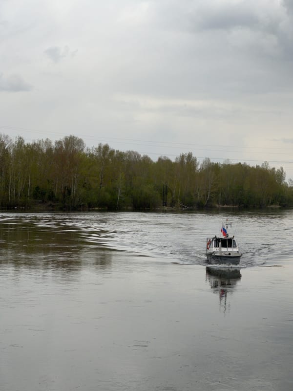 Russian flagged boat travels Yenisey River in overcast Krasnoyarsk