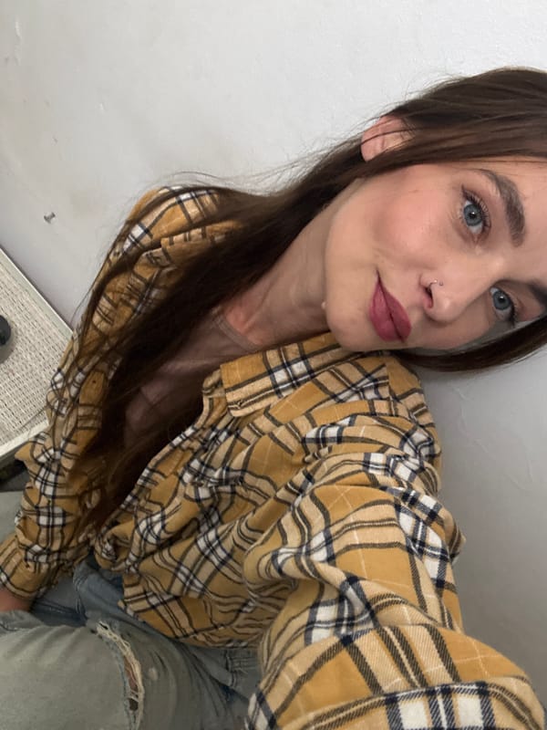 Woman takes selfie in mustard plaid shirt in Bat Yam