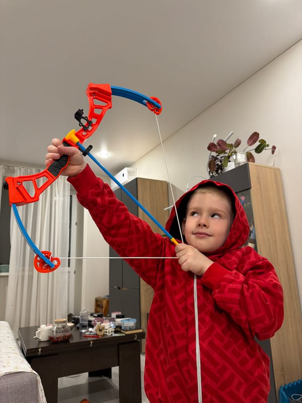 Child plays with toy bow in Russian home