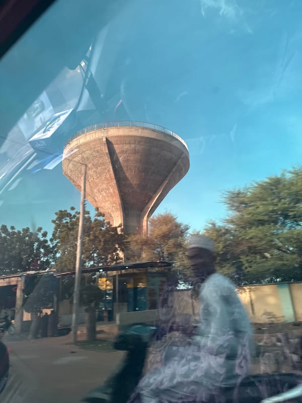 Concrete water tower dominates Batagarawa streetscape, two angles