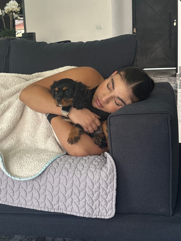 Woman naps with puppy on sofa in Puebla