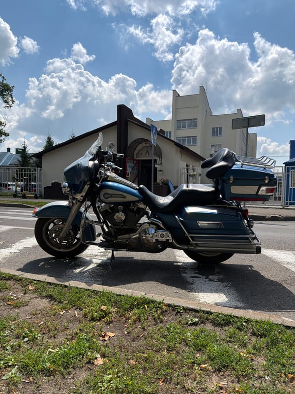 Harley parked, cyclists rolling — a quiet Minsk street corner