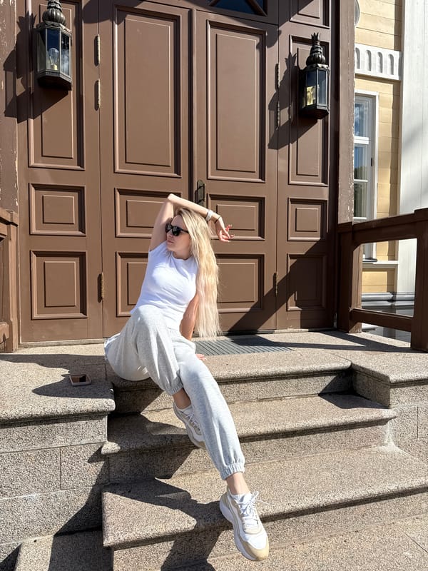 Women pose for photos on historic building steps in Vyborg