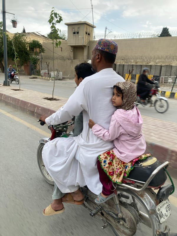 Motorcyclist in traditional dress travels through Quetta streets
