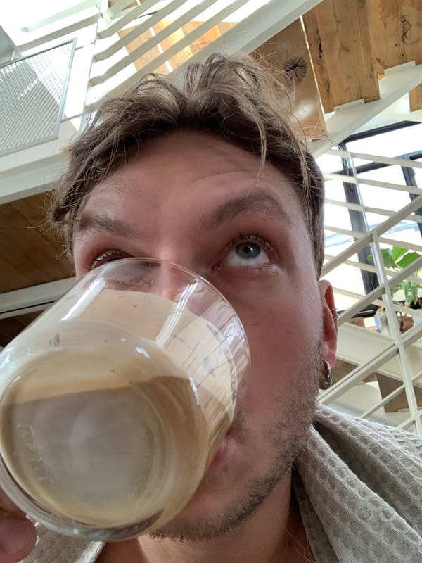 Man in robe drinks from glass in Tel Aviv