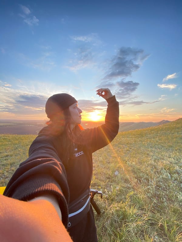 Woman spends sunset evening with toy figurine in Russian hills