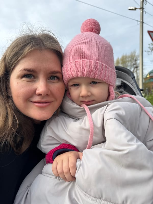 Woman and child stroll through Ферма, Russia early morning