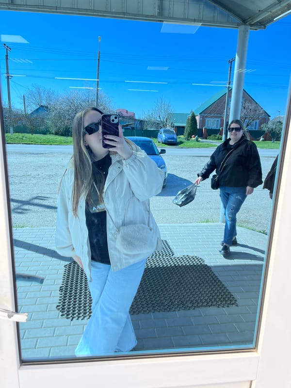 Women photograph themselves across Novopokrovskaya, Russia