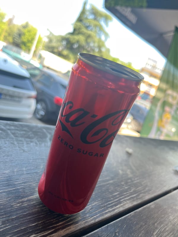 Everyday street scenes documented including beverage and parked cars