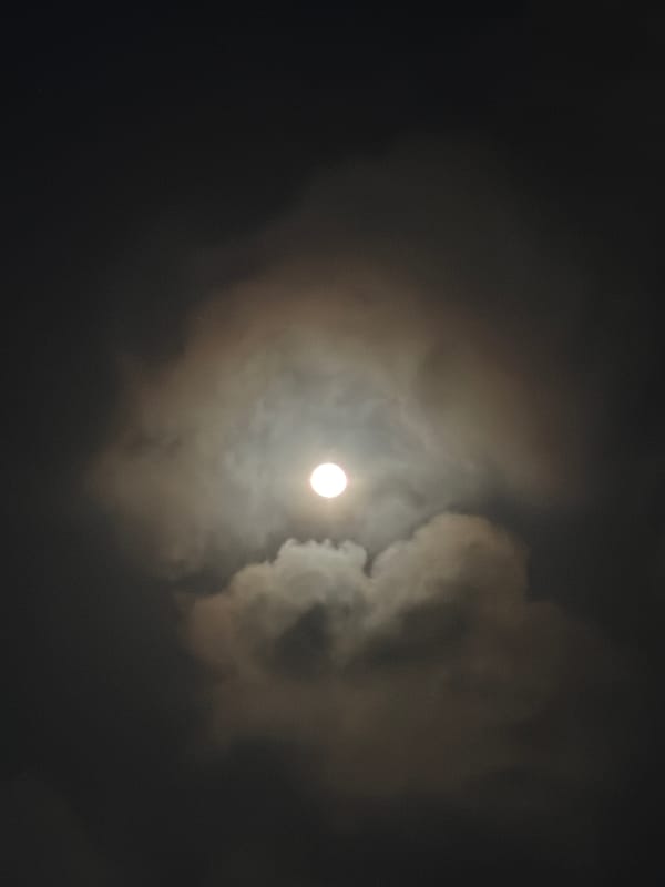 Full moon glimpsed through clouds over Igboefon, Nigeria