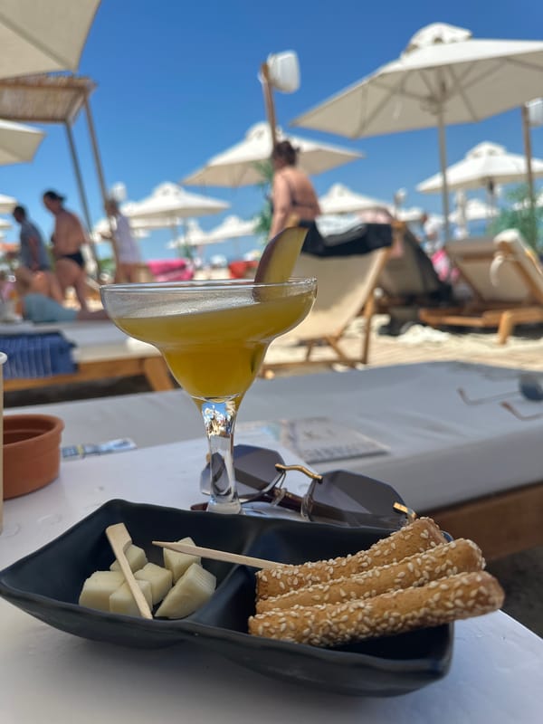 Beach club patrons enjoy drinks and sunbathing in Greece