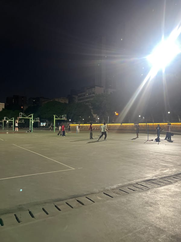 Evening badminton game observed on wet court in Yuzhong District
